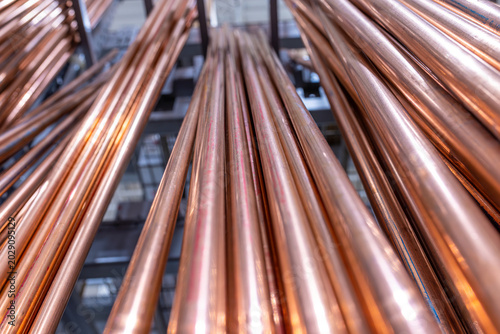 Tableau sur toile Close-up low-angle view of straight copper pipes and tubing stored on industrial