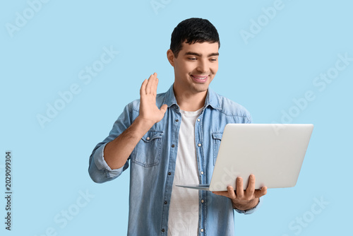 Happy young man with laptop...