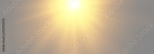 Centered golden sun flare radiating bright rays through a misty soft backdrop