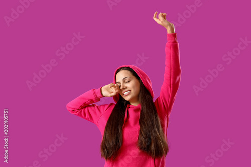 Εκτύπωση καμβά Young woman in fuchsia hoodie on purple background