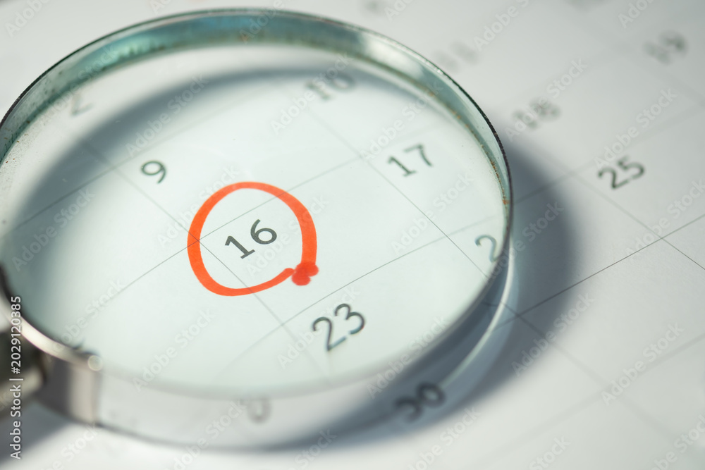 Fototapeta premium Deadline Reminder on Calendar Through Magnifying Glass, Important Date and Time Management Concept.