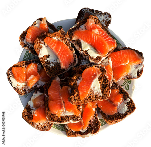 Obraz na plátne Sandwiches of rye bread with butter and red fish on the dish isolated on white h