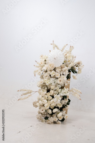 Detail with white japanese vibe umbrela, Elegant white flowers cascade upward in graceful tiers. Delicate blooms and soft petals frame a clean, minimalist backdrop. Neutral tones enhance purity
