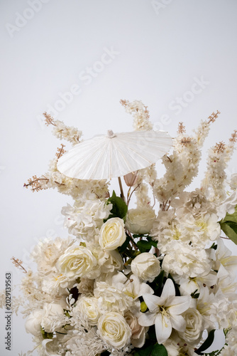 Detail with white japanese vibe umbrela, Elegant white flowers cascade upward in graceful tiers. Delicate blooms and soft petals frame a clean, minimalist backdrop. Neutral tones enhance purity