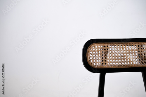 Warm wooden chairs with woven cane backs. Curved seats and slender legs create elegant design. Simple, minimalist style suits modern interiors. Ideal for cafes, homes, or cozy dining spaces.