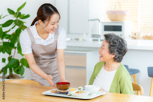 食事の準備をするヘルパーとシニア女性