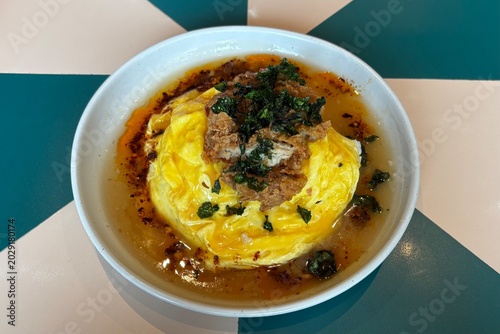 Spicy curry rice with egg omelet and crispy kale on a white plate. A contemporary restaurant menu.