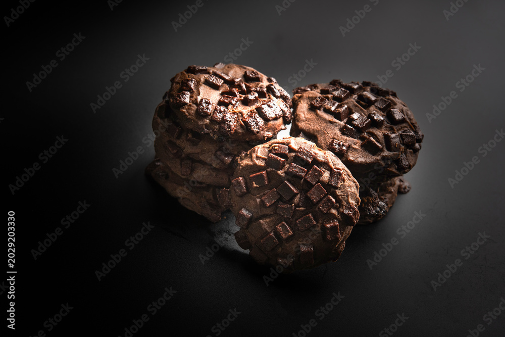 Φωτογραφία Chocolate cookie with chocolate chunk topping, baked cookie stack on dark surfac
