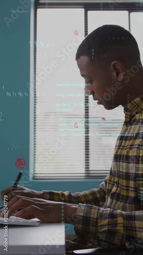 Vertical video: Developer typing and noting with pen on monitor cue, tech code flowing over hands