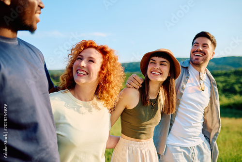 Φωτογραφία Group of happy diverse friends smiling and laughing together while walking outdo