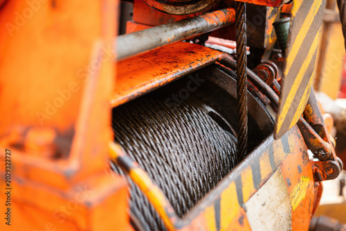An air winch machine on the drilling rig floor, assembly with iron wirerope sling, the equipment using for lifting heavy equipment in the drilling operation. Industrial equipment object, close-up.