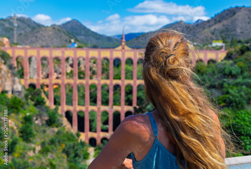 Tablou pe pânză woman looking at acueducto del aguila, aqueduct with blurred background in nerja