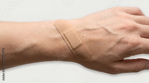 Close-up of hand with bandage on wrist, showing minor injury and care.