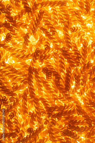 pasta spirals made at the factory top view, macro, background, yellow, pasta