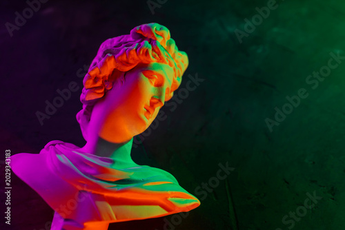 Cuadro en lienzo Classical sculpture bust with vibrant neon rainbow gradient lighting on dark bac