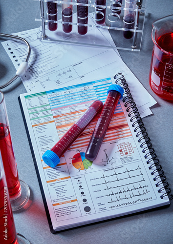 Clinical laboratory blood sample analysis, medical diagnostic test tubes on healthcare reference chart, hospital research workspace
