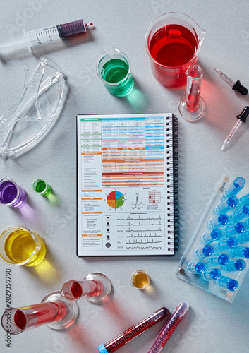 Medical research notebook with laboratory chemicals and test tubes