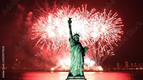 Statue of Liberty at night surrounded by a large fireworks display.