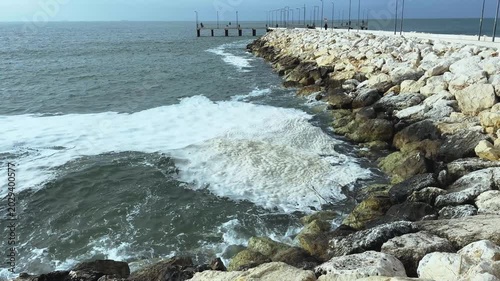Dirty textured foam surface made by waves of water. Close-up view of shore of a lake, river or sea.