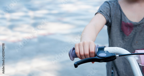Child on a bicycle. Hand on the handlebars of a children's bicycle. Handbrake.
