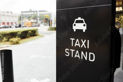 Konstfotografi Taxi stand sign on a city street with black background and white lettering indicating taxi pickup point