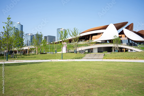 Foto Modern park green space with flowing architectural landscape and city skyline in