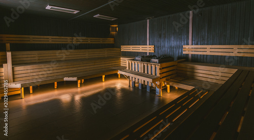 Photos Interior of an empty large traditional dry sauna with wooden benches and a centr