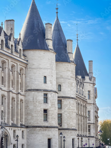 Historic medieval white stone towers and Gothic facade of the Conciergerie palace on the banks of the Seine River in Paris, France