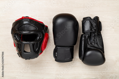 Foto Boxing helmet and gloves on wooden background, top view.