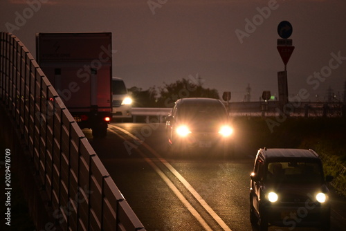 Konstfotografi ヘッドライトを点灯して走る夜の車