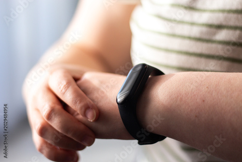 Photos Person glancing at smartwatch briefly then returning to everyday routine