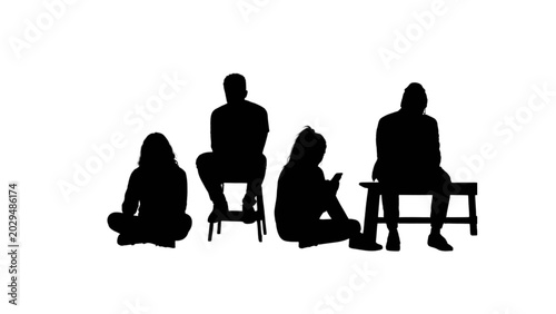 Silhouettes of four people sitting and using devices in a casual setting