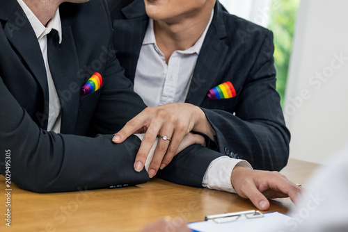 Legal status of same-sex marriage, LGBT human rights, equality and freedom concept. Two gay with diamonds ring prepare to sign in marriage paper for marriage certificate.