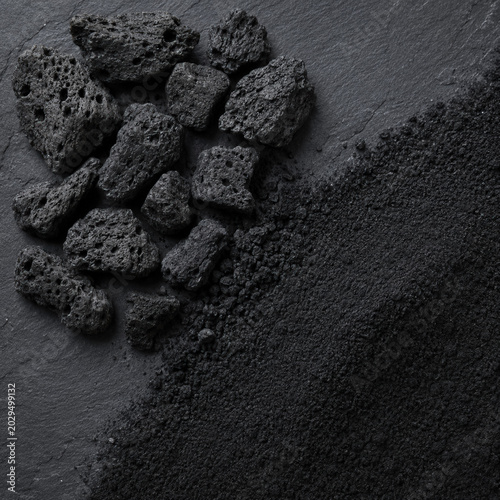 Diagonal split macro comparison of biochar granules versus activated carbon powder on black slate, sustainable carbon material types for soil amendment and water filtration, material science editorial