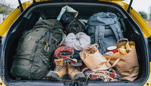 Open car trunk packed chaotically for camping