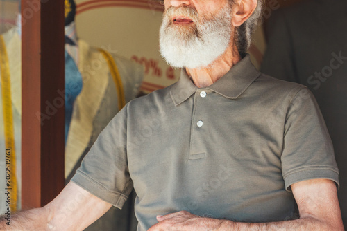 Portrait of a Senior Man with a White Beard Standing Outside a Local Shop