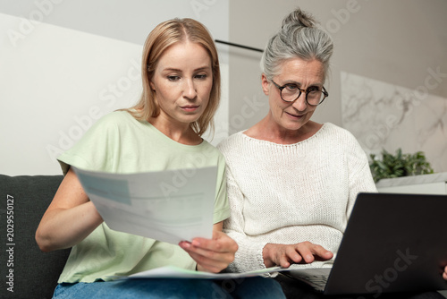 Young adult daughter helps senior mother with important documents