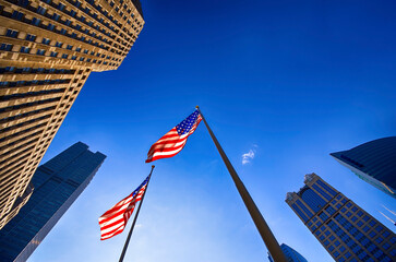 USA, Illinois, Chicago, view to facades of skyscrapers and two American flags from below
