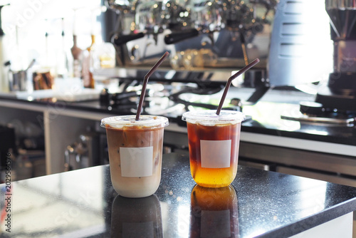 Obraz na plátně Plastic glasses of iced americano and coffee latte on marble counter