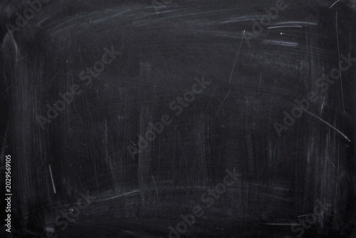 Texture of a dark chalkboard with traces of chalk creating a dark and moody background