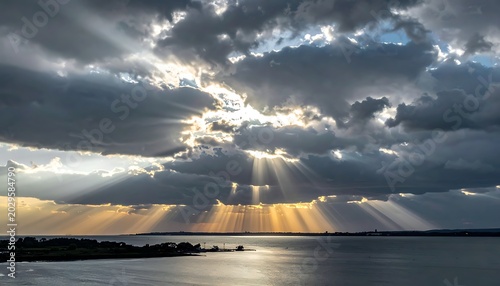A serene seascape with sunbeams piercing through clouds