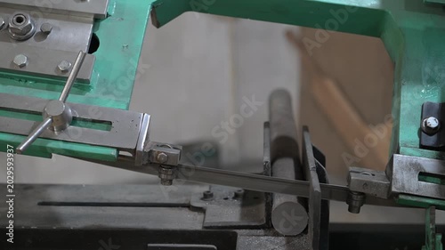 Electric metal cutting machine in the production room of the workshop. Electric hacksaw movement close-up