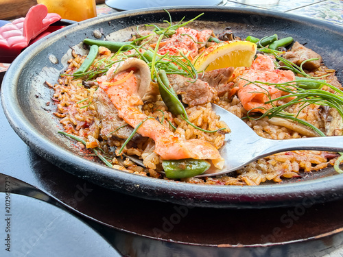 Foto スペインの米料理、パエリア。サーモンと牛肉をトッピング。