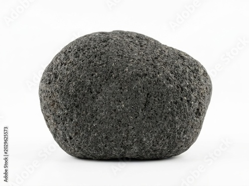 Single black rough textured basalt stone on white background rock