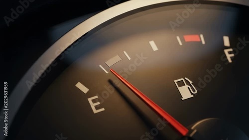 Fuel Gauge Close-Up: A detailed close-up of a car's fuel gauge showing the needle nearing empty, indicating low fuel level and the need for refueling.