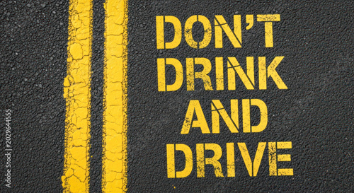 Warning message on asphalt road surface with yellow lines stating 