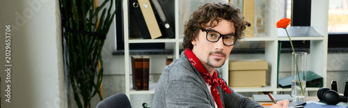 Φωτογραφία Handsome young man in modern office showcasing creativity and style while workin