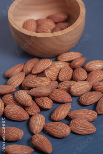 Almonds rest on a simple piece of paper, highlighting their natural texture in a clean minimal scene.