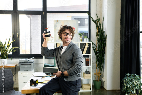 Canvas Print Cheerful young professional enjoying his workday in a modern office setting