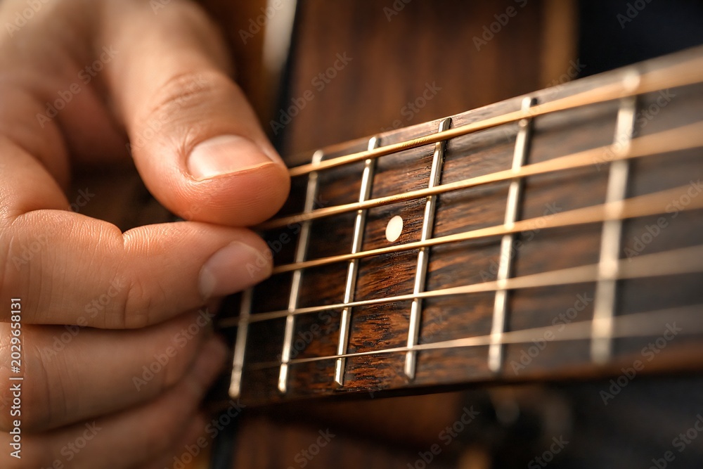 Fototapeta premium Close-up of Hands Playing Guitar Strings and Frets Music Performance and Hobby Concept